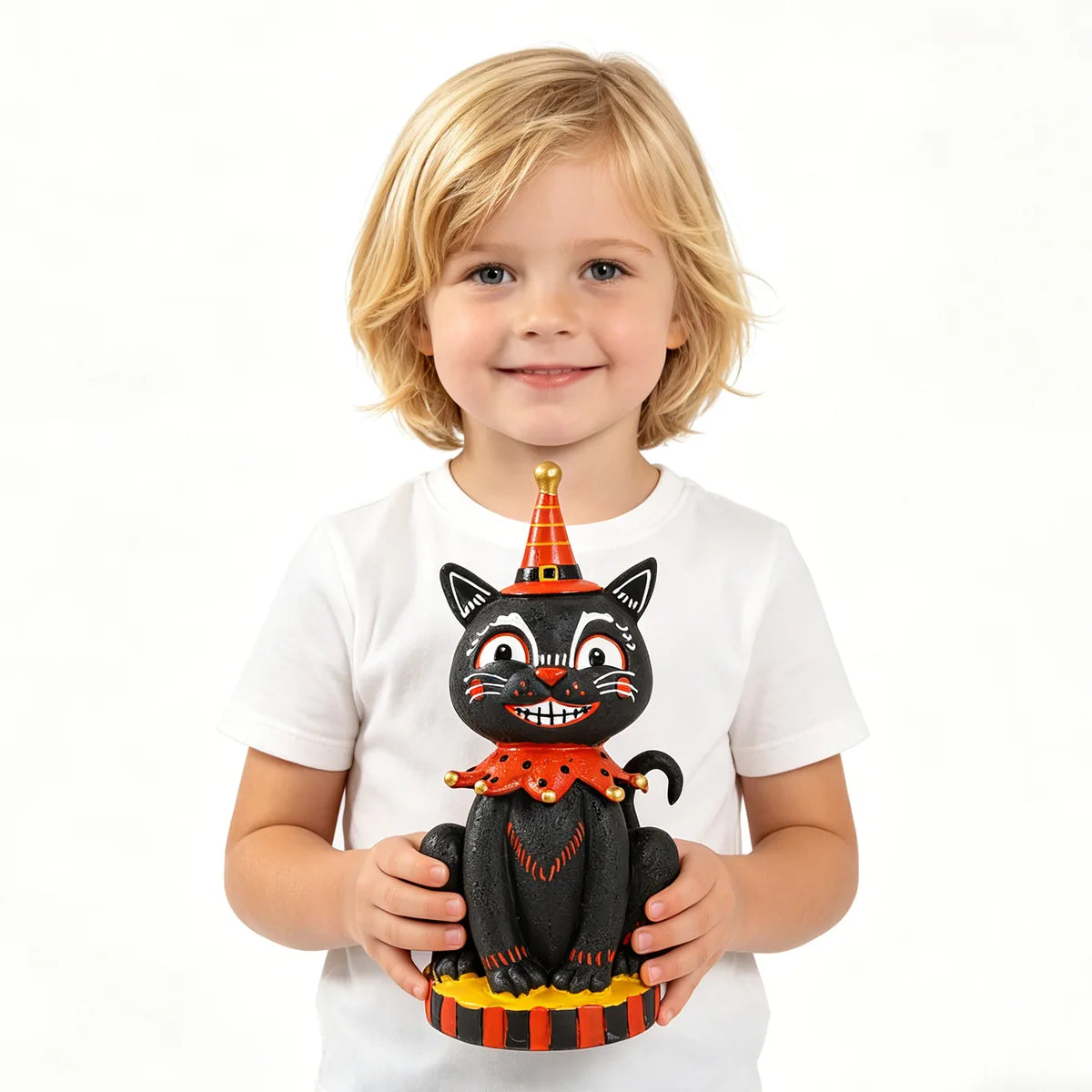 Child holds the smiling black cat figurine to show its scale.
