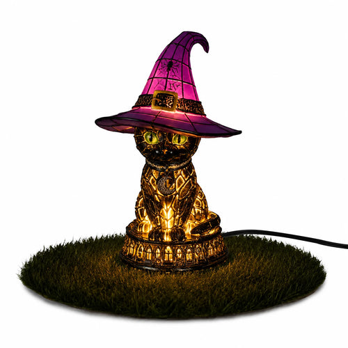 Illuminated witch hat lamp shaped like a black cat, glowing warmly on a grass display.